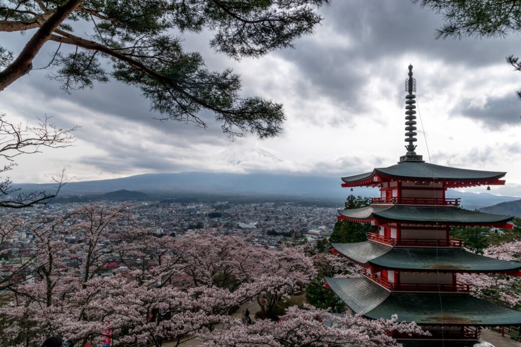 red and white temple near trees and body of water during daytime. Shizuoka cover photo