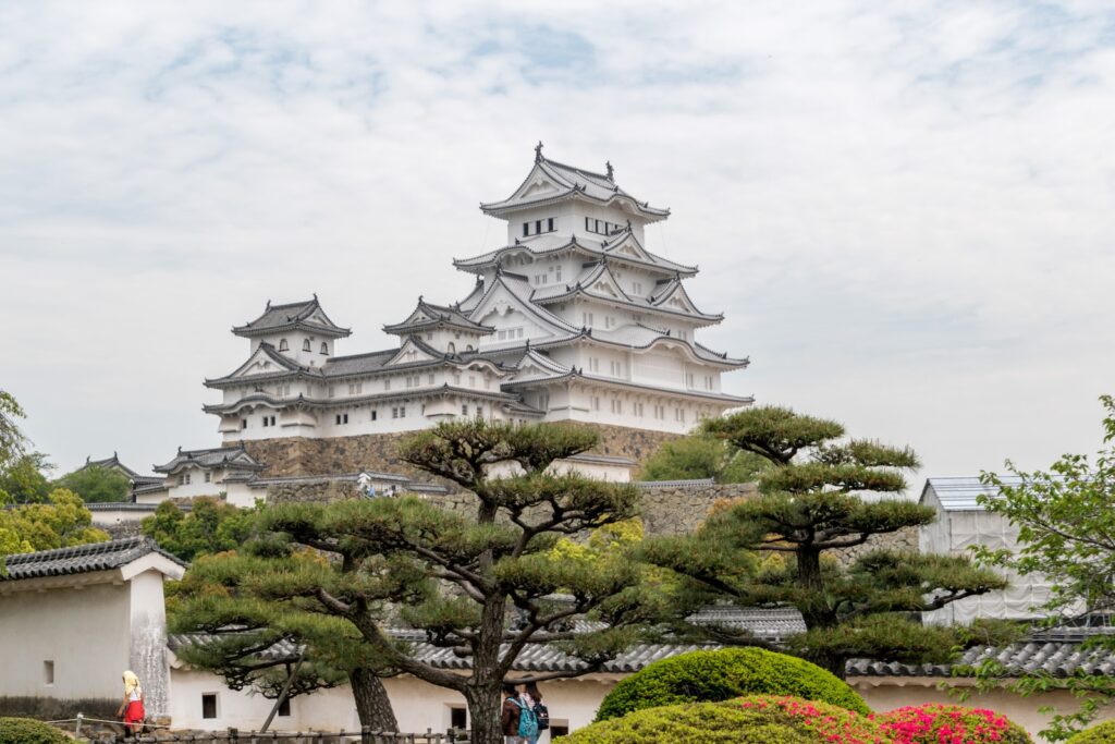 people walking on pathway near white and gray concrete building during daytime. Himeji Castle